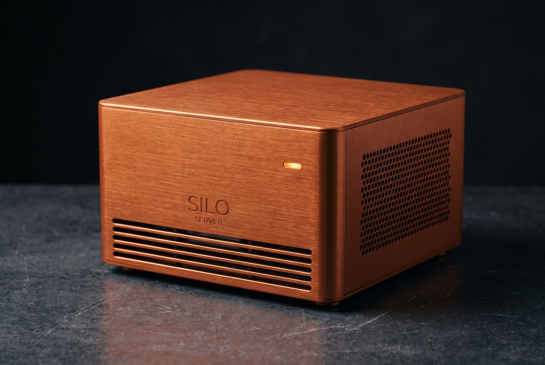 A single Silo Server module: a low, wide brushed burnt-copper anodized aluminium chassis with a square footprint, hexagonal side vent field and lit amber status lamp