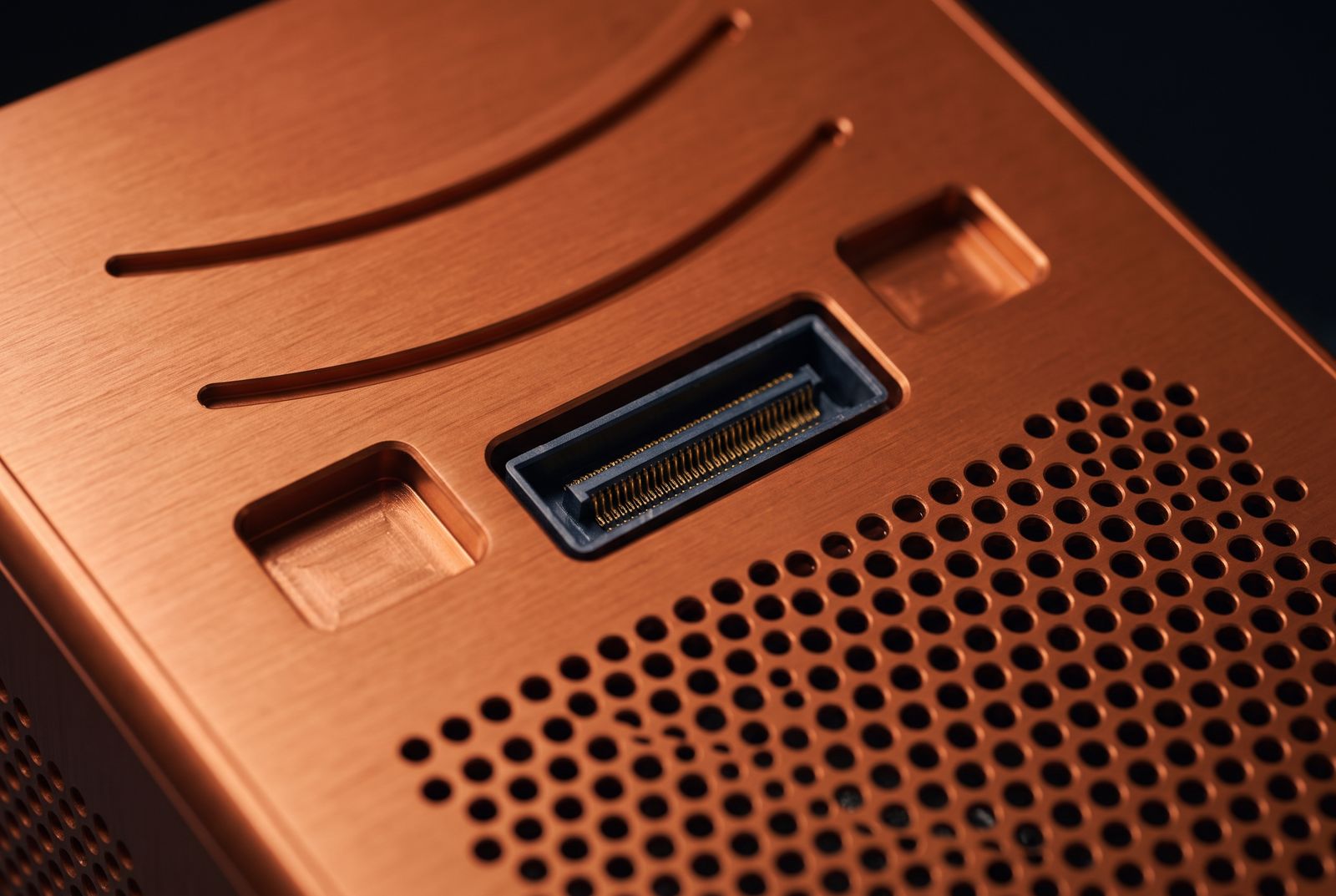 Close-up of the SiloLink mating face: machined guide channels, two recessed cam-latch pockets and a recessed rectangular blind-mate connector beside the hexagonal vent field